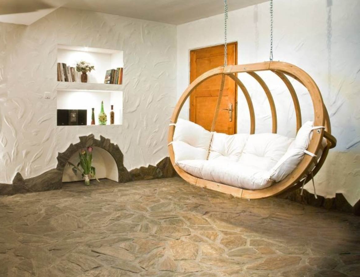 Terras met natuursteen vloer van Nibo Stone en luxe tweepersoons hangstoel van Living Luxury