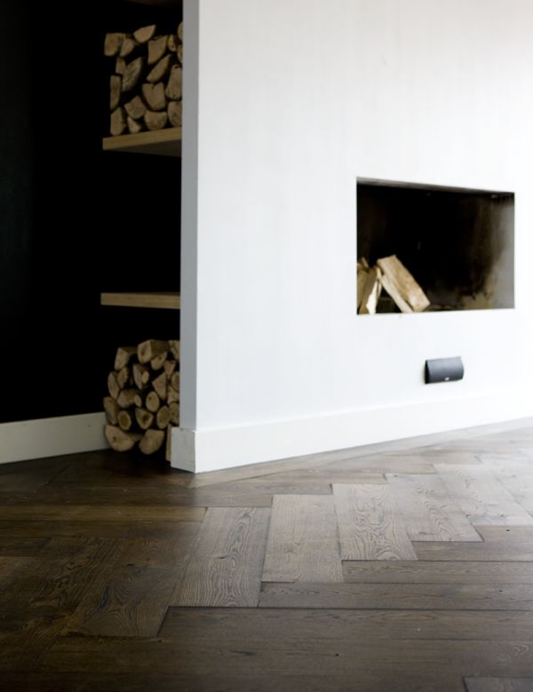 Uipkes houten vloer bij haard. Visgraat vloer zwart geolied